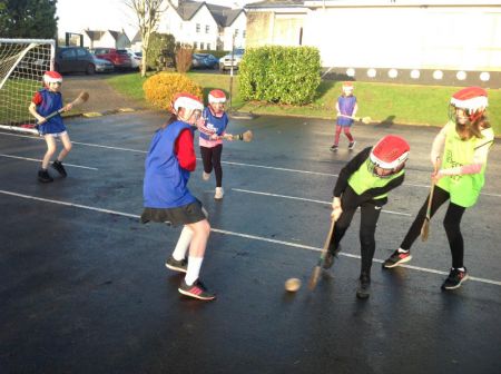 P6 & P7 enjoying a game of hurling during PE.